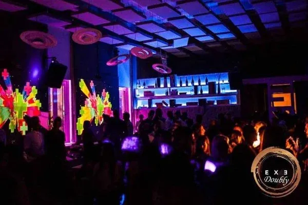 Sala dell’Exe Roma all’EUR illuminata durante la serata con il pubblico in pista