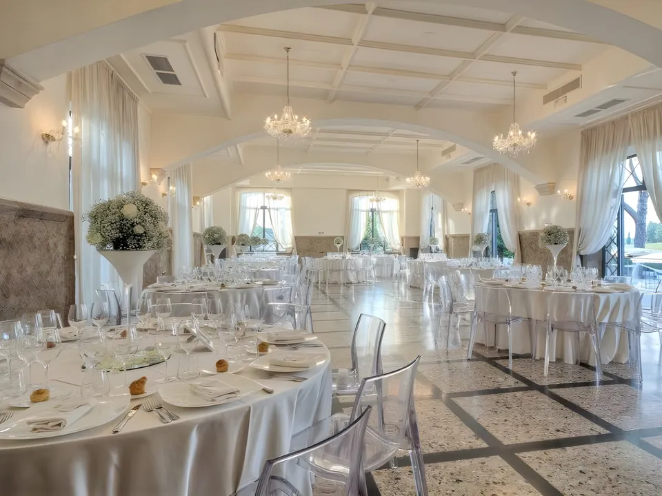 Salone interno di Villa dei Cesari con lampadari e tavoli allestiti